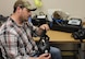 Justin Rayner conducts a visual inspection of an M50 mask after it comes out of the drying room. Rayner is a member of a small team of 13 that breaks down, inspects, repairs, cleans, sanitizes and tests about 8,000 masks each month for the Air Force. (U.S. Air Force photo/Rodney Whaley)