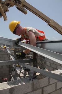 U.S. Army Spc. Chris Bebo, with the 372nd Engineer Company, directs the positioning of roof beams at the Ladyville, Belize Medical Clinic construction site, during Beyond the Horizon 2017, May 1st, 2017. Beyond the Horizon is a U.S. Southern Command-sponsored, Army South-led exercise designed to provide humanitarian and engineering services to communities in need, demonstrating U.S. support for Belize. (U.S. Army photo by Spc. Gary Silverman)