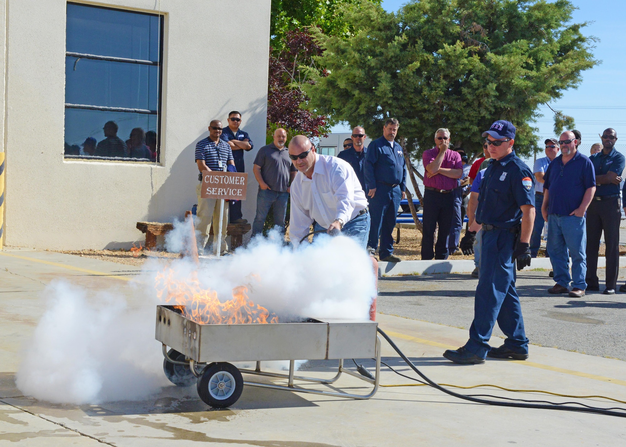 Mike Sears, 412th Logistics Readiness Squadron director, takes lead as the first person to douse a fire during a mass fire extinguisher training event for the squadron.(U.S. Air Force photo by Kenji Thuloweit)