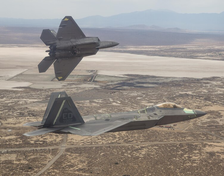 Two F-22 Raptors from the 411th Flight Test Squadron fly above the California High Desert in this photo.  Developmental tests of air-to-air missiles against an aerial target were completed April 18 at the Utah Test and Training Range as part of a major capability upgrade. (Courtesy photo by Chad Bellay/Lockheed Martin)