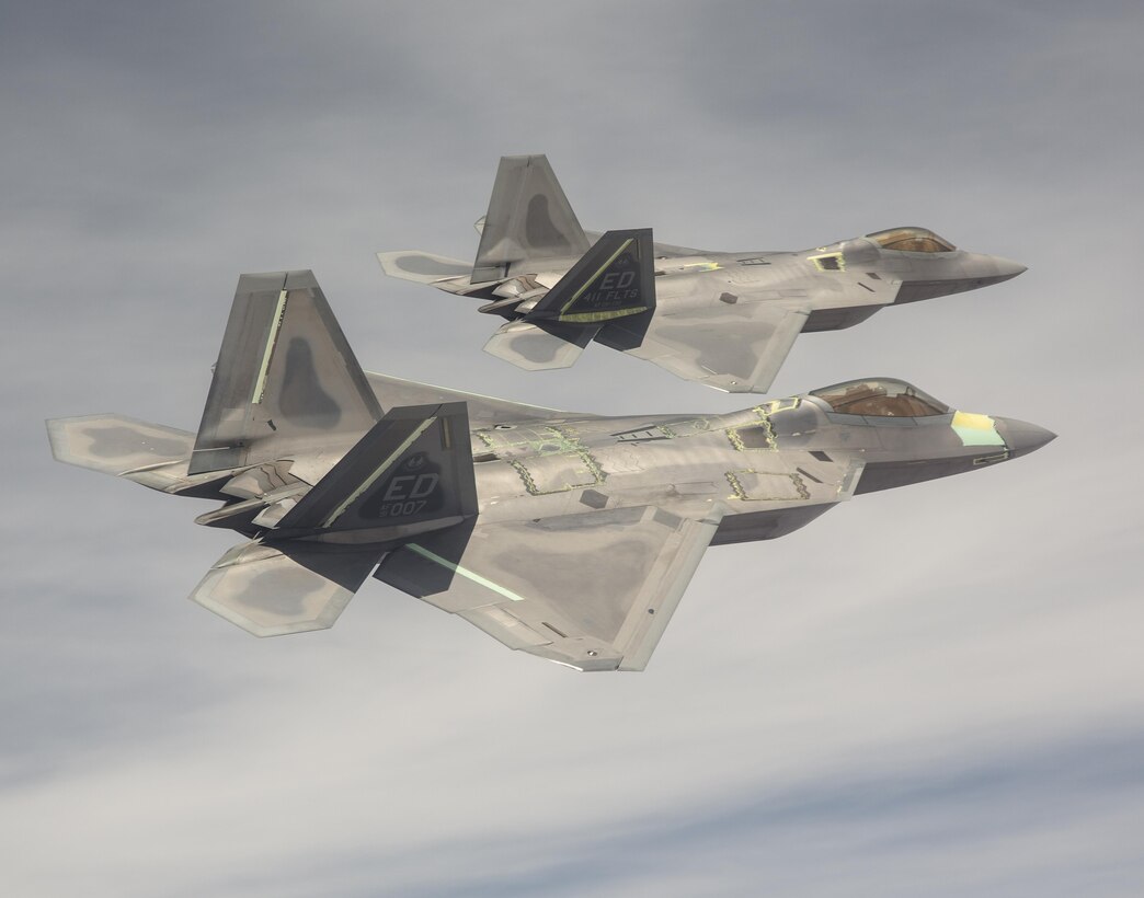Two F-22 Raptors from the 411th Flight Test Squadron fly above the California High Desert in this photo.  Developmental tests of air-to-air missiles against an aerial target were completed April 18 at the Utah Test and Training Range as part of a major capability upgrade. (Courtesy photo by Chad Bellay/Lockheed Martin)