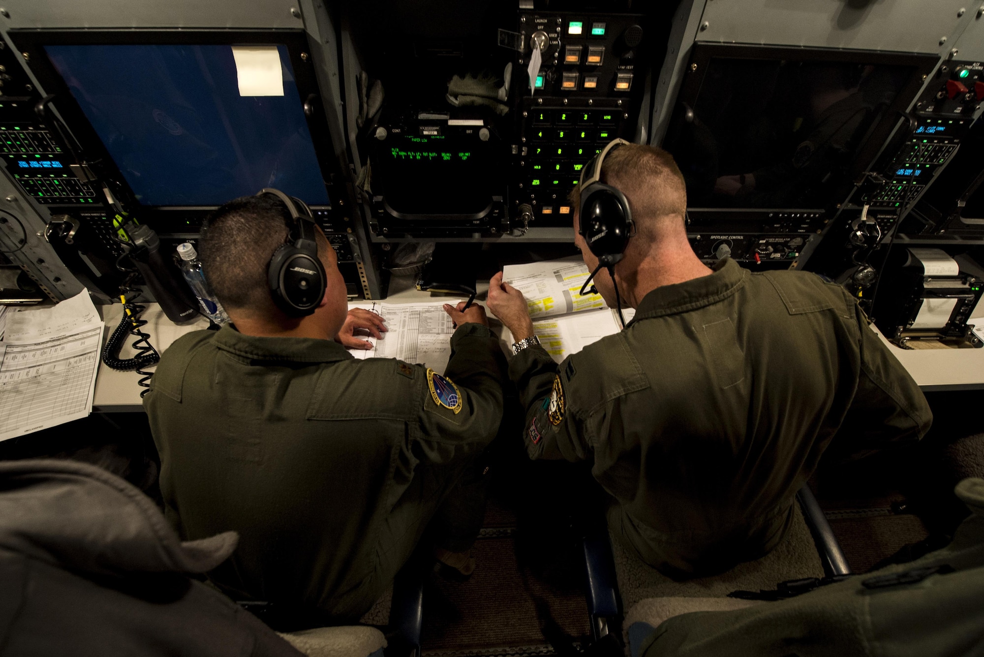 U.S. Air Force Maj. Izzy Remo, left, a test conductor-airborne, and U.S. Air Force Capt. Greg Carter, right, a deputy missile combat crew commander-airborne, both from the 625th Strategic Operations Squadron, go over missile launch procedures during Glory Flight 220 above the Pacific Ocean, April 26, 2017. Glory Trip is an operational test launch which continues a long history of launches from Vandenberg Air Force Base, Calif., used to verify, validate and improve the capability of the nation’s ICBM force. (Photo edited for security) (U.S. Air Force photo by Airman 1st Class Keifer Bowes)