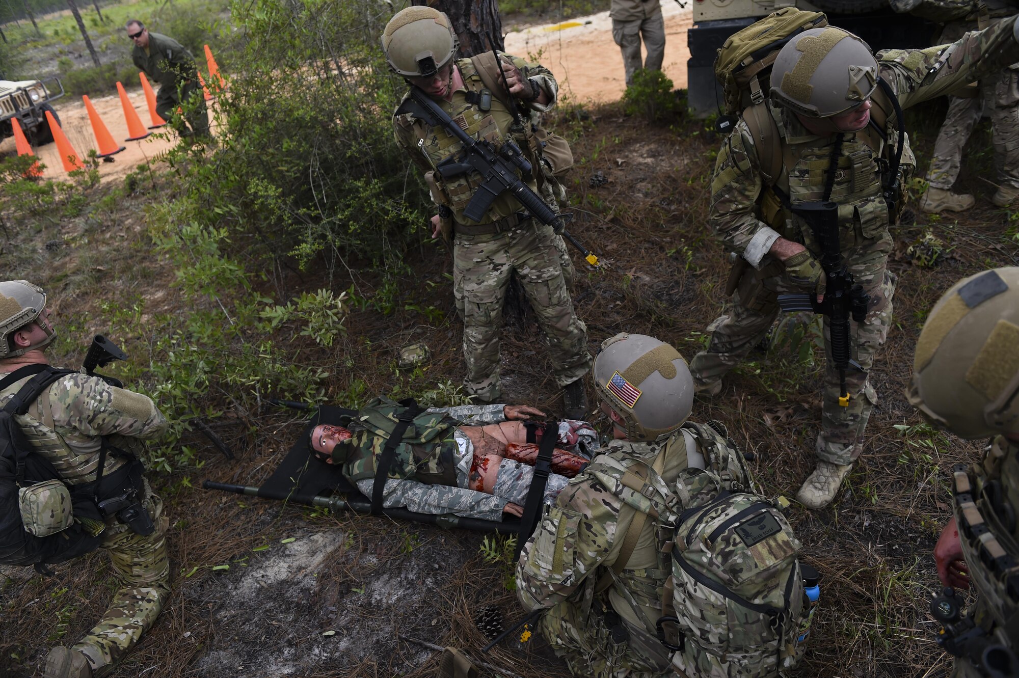 Combat aviation advisor students with the 6th Special Operations Squadron tend to a wounded casualty during Operation Raven Claw at Duke Field, Fla., April 27, 2017. Students came under simulated fire from hostile forces during a checkpoint and had to navigate through the woods to a safe location while carrying a casualty weighing approximately 210 pounds. (U.S. Air Force photo by Airman 1st Class Joseph Pick)