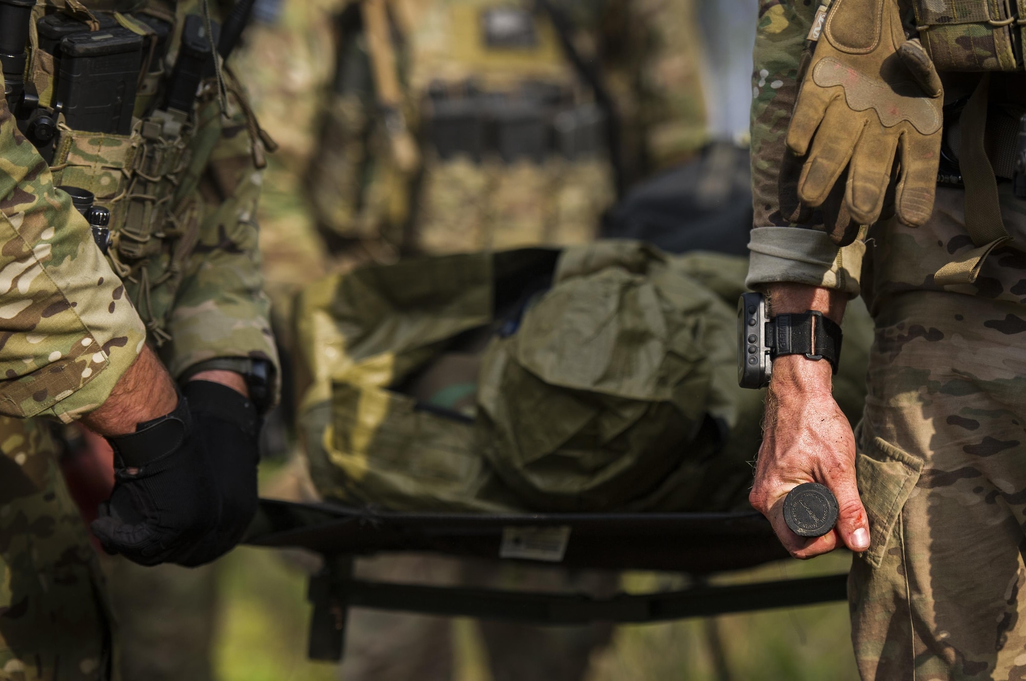 Combat aviation advisor students with the 6th Special Operations Squadron carry a litter through the woods during Operation Raven Claw at Duke Field, Fla., April 27, 2017. Students came under simulated fire from hostile forces during a checkpoint and had to navigate through the woods to a safe location while carrying a casualty weighing approximately 210 pounds. (U.S. Air Force photo by Airman 1st Class Joseph Pick)