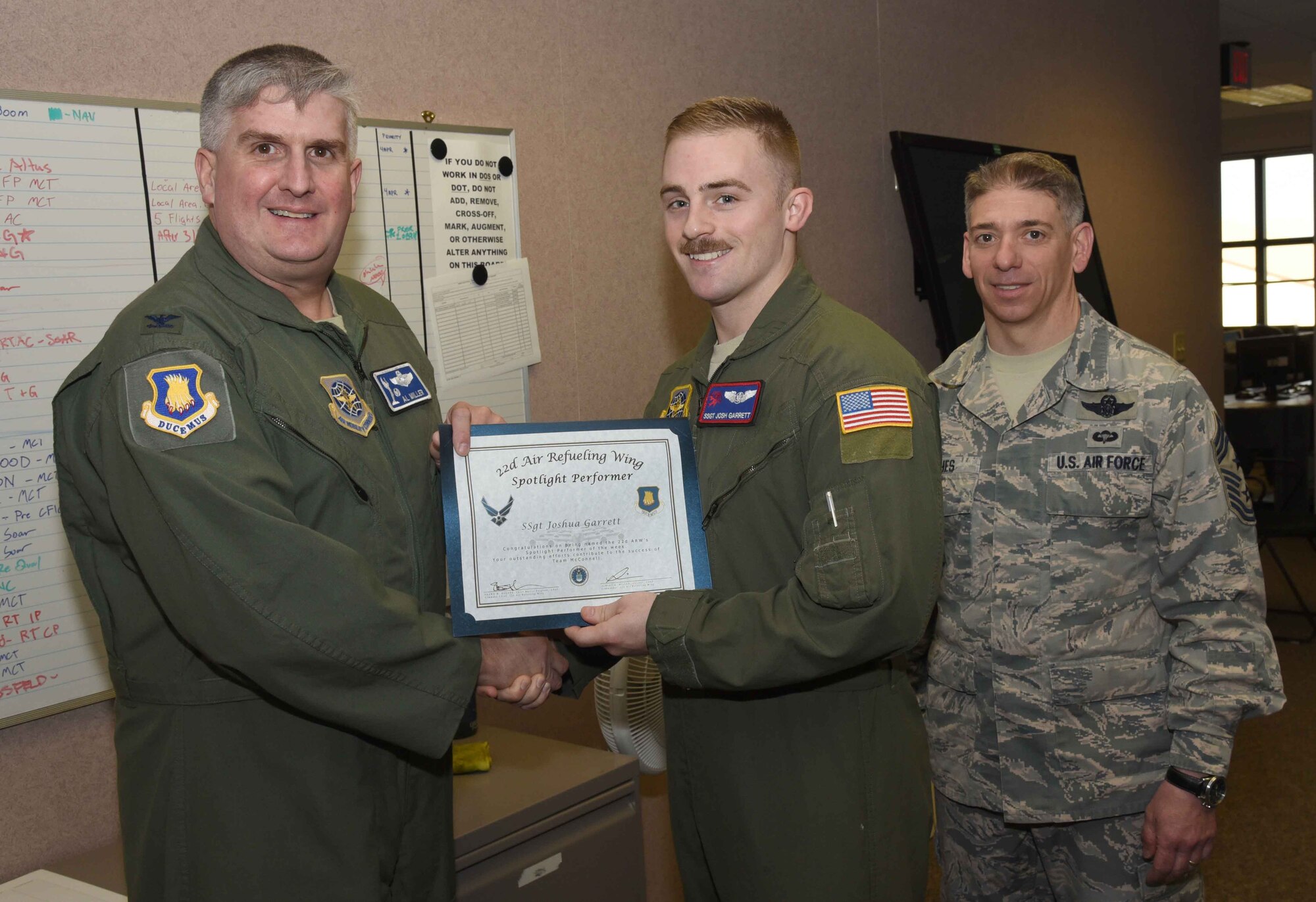 Staff Sgt. Josh Garrett, 350th Air Refueling Squadron instructor boom operator, poses with Col. Albert Miller, 22nd Air Refueling Wing commander, and Chief Master Sgt. Shawn Hughes, 22nd ARW command chief, April 6, 2017, at McConnell Air Force Base, Kan. Garrett received the spotlight performer for the week of March 27-31. (U.S. Air Force photo/Airman 1st Class Erin McClellan)