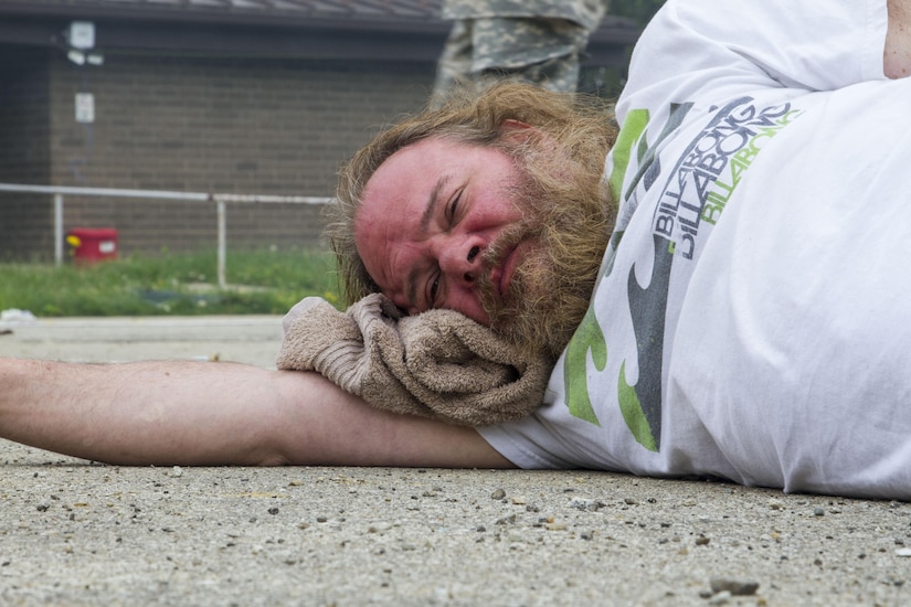Civilian role player Derek Pastrick, a Columbus, Ind., resident, lies on the ground awaiting help following a mock nuclear disaster at the Muscatatuck Urban Training Center, April 28, 2017. The U.S. Army Reserve’s Guardian Response 2017 is a multi-component training exercise designed to validate more than 4,000 service members in Defense Support of Civil Authorities in the event of a Chemical, Biological, Radiological and Nuclear catastrophe. This year's exercise simulated an improvised nuclear device explosion with a source region electromagnetic pulse out to more than four miles. The 84th Training Command hosted this exercise and the 78th Training Division, headquartered in Joint Base McGuire-Dix-Lakehurst, New Jersey, conducted the training operations. (U.S. Army Reserve photo by Sgt. Beth Raney, 343rd Mobile Public Affairs Detachment)