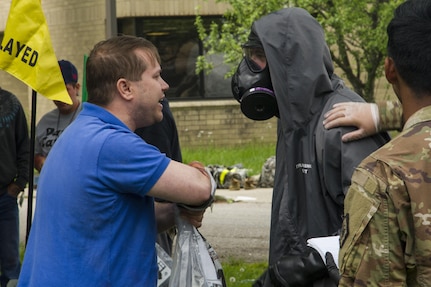 A civilian role player explains his simulated injuries to a U.S. Army Reserve Soldier following a mock nuclear disaster at the Muscatatuck Urban Training Center, Ind., April 28, 2017. The U.S. Army Reserve’s Guardian Response 2017 is a multi-component training exercise designed to validate more than 4,000 service members in Defense Support of Civil Authorities in the event of a Chemical, Biological, Radiological and Nuclear catastrophe. This year's exercise simulated an improvised nuclear device explosion with a source region electromagnetic pulse out to more than four miles. The 84th Training Command hosted this exercise and the 78th Training Division, headquartered in Joint Base McGuire-Dix-Lakehurst, New Jersey, conducted the training operations (U.S. Army Reserve photo by Sgt. Beth Raney, 343rd Mobile Public Affairs Detachment)