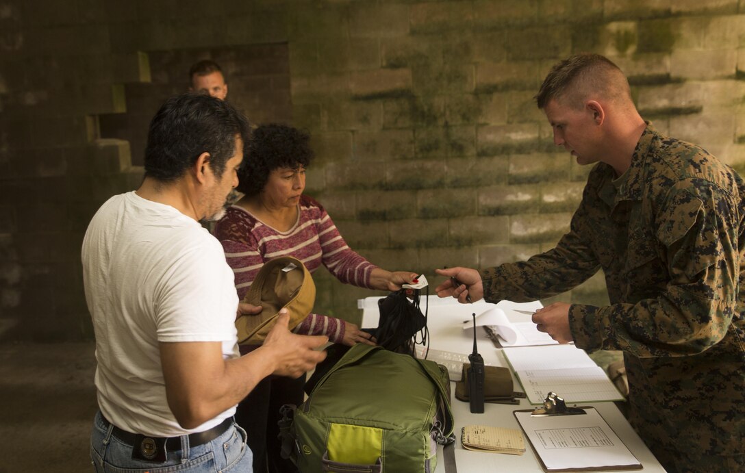 CAMP LEJEUNE, N.C. – Lance Cpl. Austin S. Coon, a combat engineer with the Logistics Combat Element, Special Purpose Marine Air-Ground Task Force - Southern Command, checks role players’ identification cards at a simulated evacuation control center during General Exercise 2 at Marine Corps Base Camp Lejeune, North Carolina, April 29, 2017. The Marines simulated a noncombatant evacuation operation in order to prepare for crisis response situations they could face during their deployment to Central America. (U.S. Marine Corps photo by Sgt. Ian Leones)