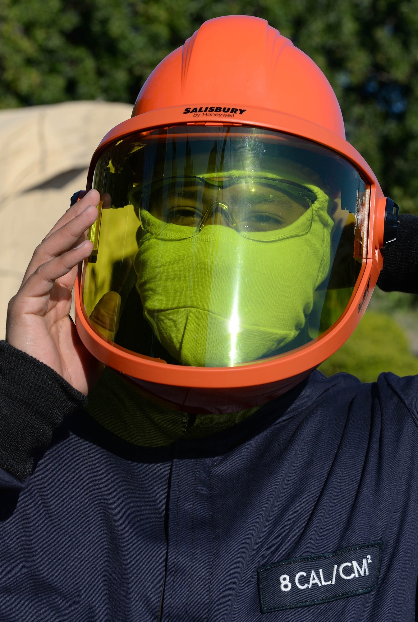 U.S. Air Force Senior Airman Enrique Flores, an electric systems journeyman with the 635th Materiel Maintenance Squadron out of Holloman Air Force Base, N.M., puts on a face guard prior to connecting electricity to a newly-constructed laundry facility in the Dominican Republic, March 29, 2017, as part of NEW HORIZONS 2017. The face guard is used to protect against heat that could be caused by an electrical panel if it were to explode. (U.S. Air Force photo by Staff Sgt. Timothy M. Young)