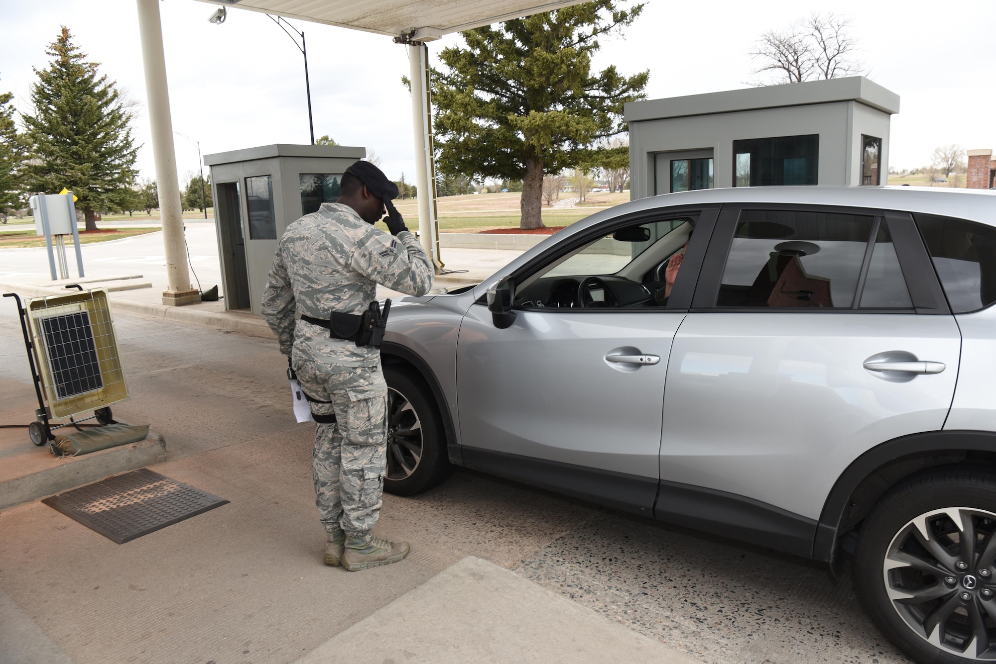 Airman 1st Class Zarquis Butler, 90th Security Forces Squadron installation entry controller, salutes an officer at F.E. Warren Air Force Base, Wyo., May 1, 2017. Defenders must render proper customs and courtesies while on shift. Defenders at the gate are the first line of defense for the installation. (U.S. Air Force photo by Airman 1st Class Breanna Carter) 