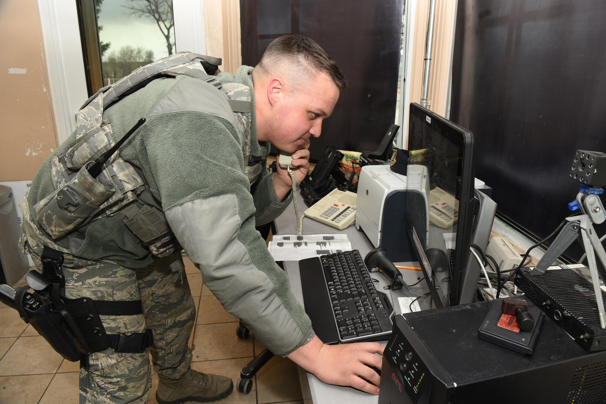 Airman 1st Class Ramon Cruz, 90th Security Forces Squadron installation entry controller, makes a phone call at F.E. Warren Air Force Base, Wyo., May 1, 2017. The gate guards have frequent contact with the law enforcement desk, which provides them with information and help to further defend the base. (U.S. Air Force photo by Airman 1st Class Breanna Carter)