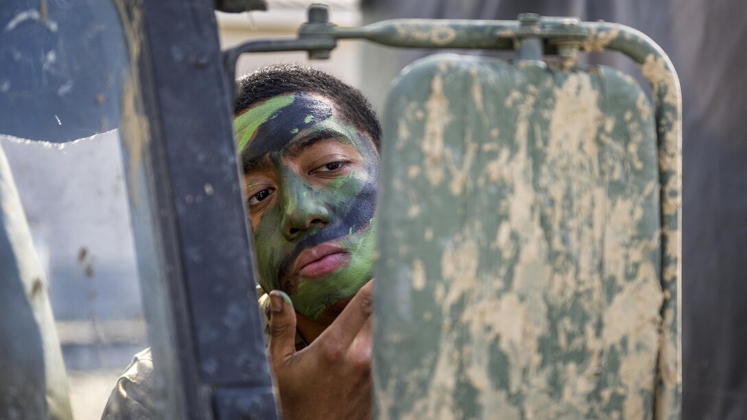 A paratrooper applies face paint while participating in a live-fire training event at the Infantry Platoon Battle Course at Joint Base Elmendorf-Richardson, Alaska, April 26, 2017. The soldier is assigned to Scout Platoon, Headquarters and Headquarters Company, 1st Battalion, 501st Parachute Infantry Regiment. Air Force photo by Alejandro Peña