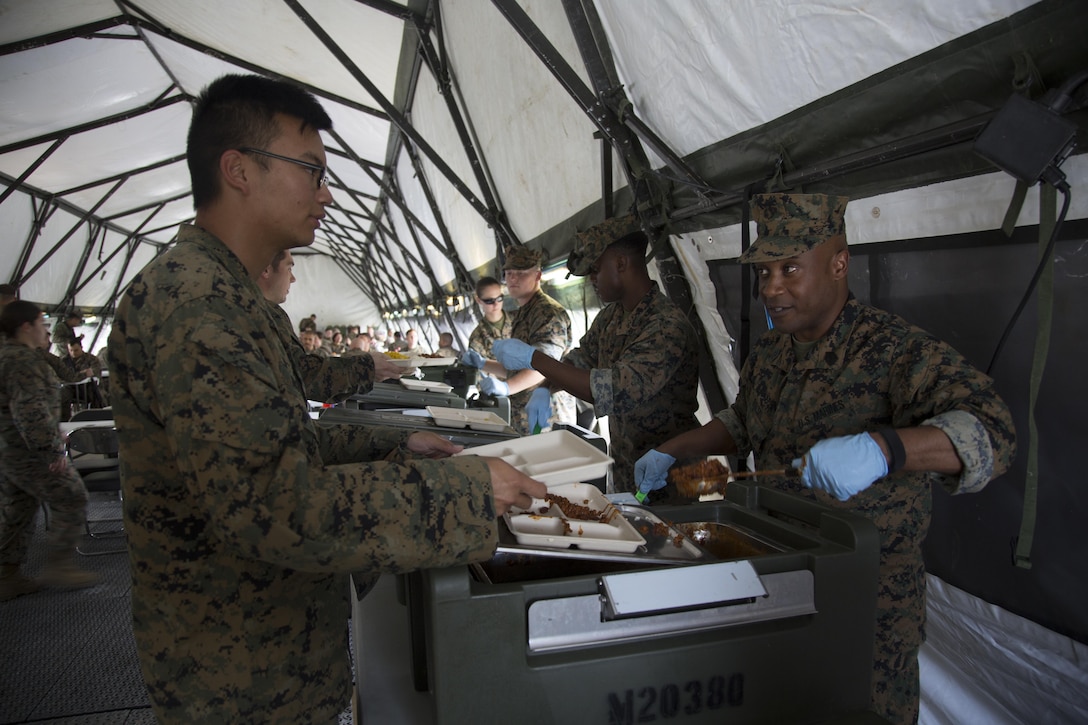 United States Marine Corps Sgt. Maj. Mario P. Fields, sergeant Major of III Marine Expeditionary Force Headquarters Group, serves lunch to III MEF Marines during Marine Expeditionary Force Exercise 17, at Camp Hansen, Okinawa, Japan, April 21, 2017. The command and control exercise prepared III MEF commanders and staff to integrate with international allies and partner nations in a combined joint task force, charged with accomplishing a wide range of military operations. Fields is a native of Jacksonville, North Carolina. (U.S. Marine Corps Photo By Lance Cpl. Austyn Krecicki)