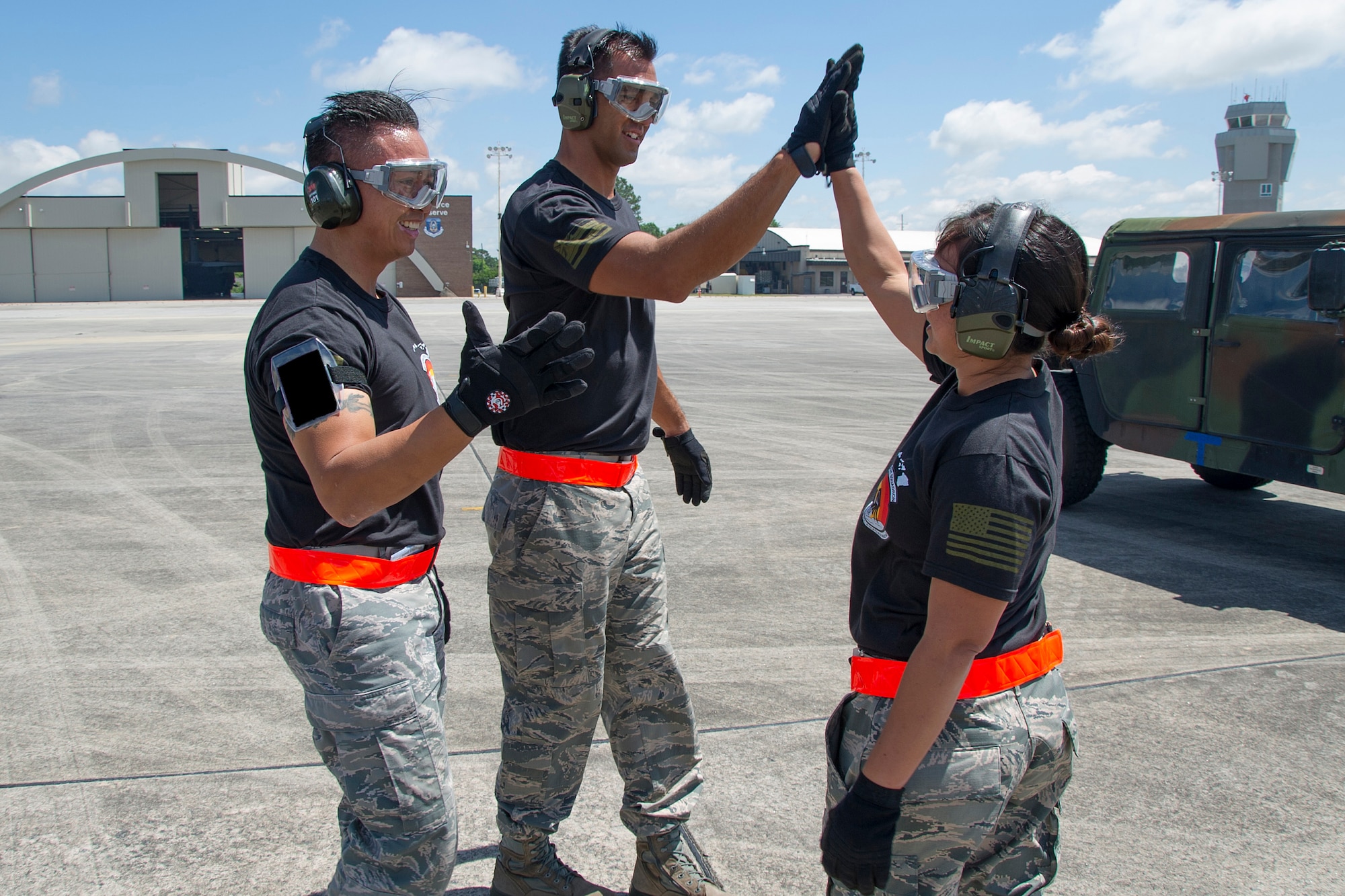 Reserve Citizen Airmen Tech. Sgt. Eric Ignacio, Master Sgt. Alfred Van Gieson, and Staff Sgt. Amber Picon, members of the 48th Aerial Port Squadron, celebrate after competing in the engine off and on load event during the Port Dawg Challenge at Dobbins Air Reserve Base, Ga., April 25, 2017.  The 48th APS was one of 23 teams competing in the 4th biennial Air Force Reserve Command's Port Dawg Challenge, which was designed to test and maintain the camaraderie of aerial port Airmen while promoting professionalism, leadership, training and communication between "Port Dawgs." The 48th APS, located on Joint Base Pearl Harbor-Hickam, Hawaii, is a component of the Air Force Reserve, providing expertise in all areas of air terminal operations to include aircraft loading, cargo processing and inspecting, passenger services, aircraft fleet services and aerial port command and control. (U.S. Air Force photo by Master Sgt. Theanne K. Herrmann)