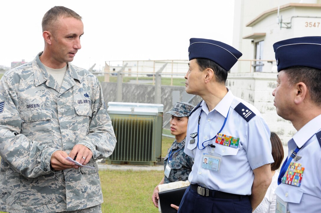 U.S. Air Force Tech. Sgt. Jeffrey Green, 18th Logistics Readiness Squadron fuels facilities NCO in charge, speaks with Japan Air Self-Defense Force Col. Riichi Furugaki, JASDF Air Staff College director of education department, and JASDF Col. Tooru Oota, JASDF Air Staff College head of education section, April 27, 2017, at Kadena Air Base, Japan.  Japan Air Self-Defense Force Air Staff College members were invited to see the different fuel capabilities of the 18th LRS petroleum, oils and lubricants flight, share information and ask questions. (U.S. Air Force photo by Senior Airman Lynette M. Rolen)