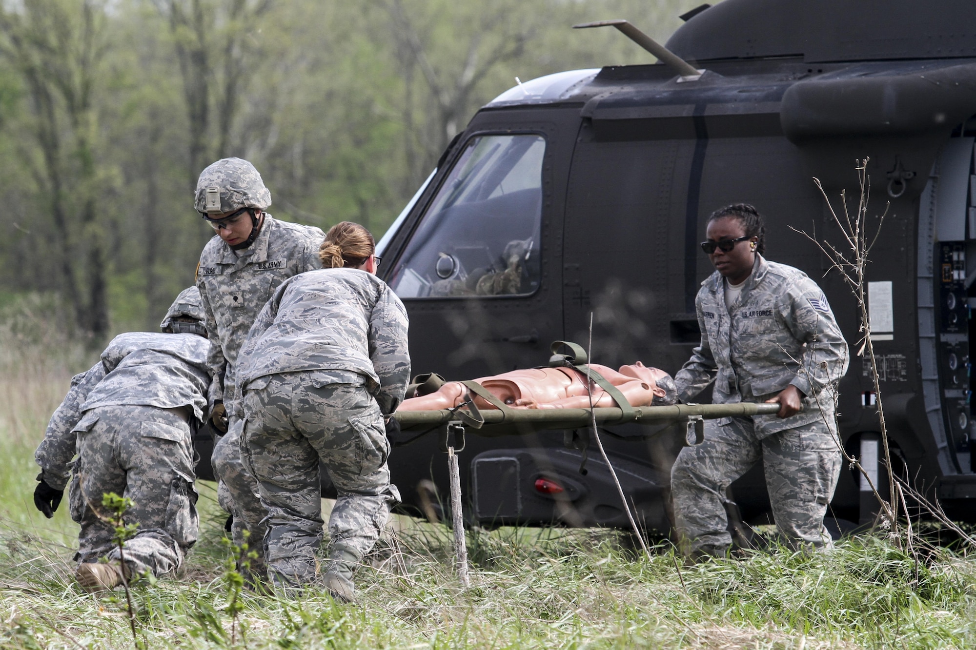 Army Reserve Spc. Ryan Flores and Spc. Bailey Jungmann of the 469th Medical Company, Wichita, Kan., team with Air Force Staff Sgt. Cherrelle Warren and Airman 1st Class Echo Heldreth of the 6th Medical Group from MacDill Air Force Base, Fla., rush to transport a mannequin patient from a UH-60 Black Hawk helicopter at Responders Support Camp Nighthawk, Ind., during Guardian Response 17, April 29, 2017. Nearly 5,000 Soldiers and Airmen from across the country participated in Guardian Response 17, a multi-component training exercise to validate the military's ability to support civil authorities in the event of a chemical, biological, radiological, and nuclear catastrophe. (U.S. Army Reserve photo by Staff Sgt. Christopher Sofia)