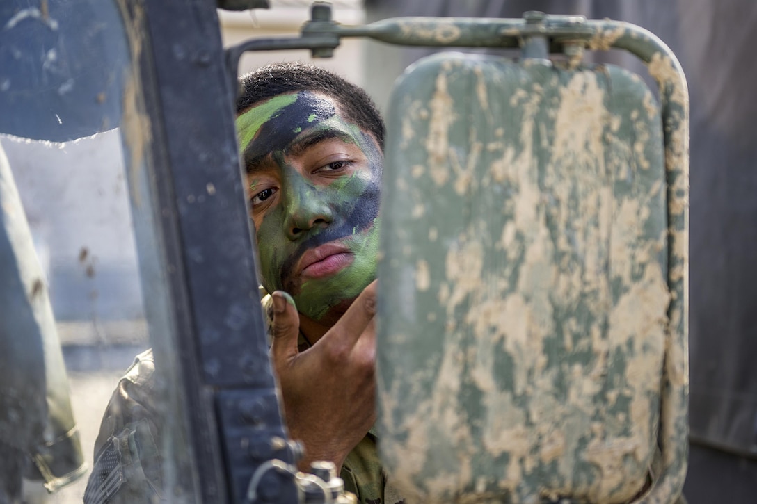 A paratrooper applies face paint while participating in a live-fire training event at the Infantry Platoon Battle Course at Joint Base Elmendorf-Richardson, Alaska, April 26, 2017. The soldier is assigned to Scout Platoon, Headquarters and Headquarters Company, 1st Battalion, 501st Parachute Infantry Regiment. Air Force photo by Alejandro Peña