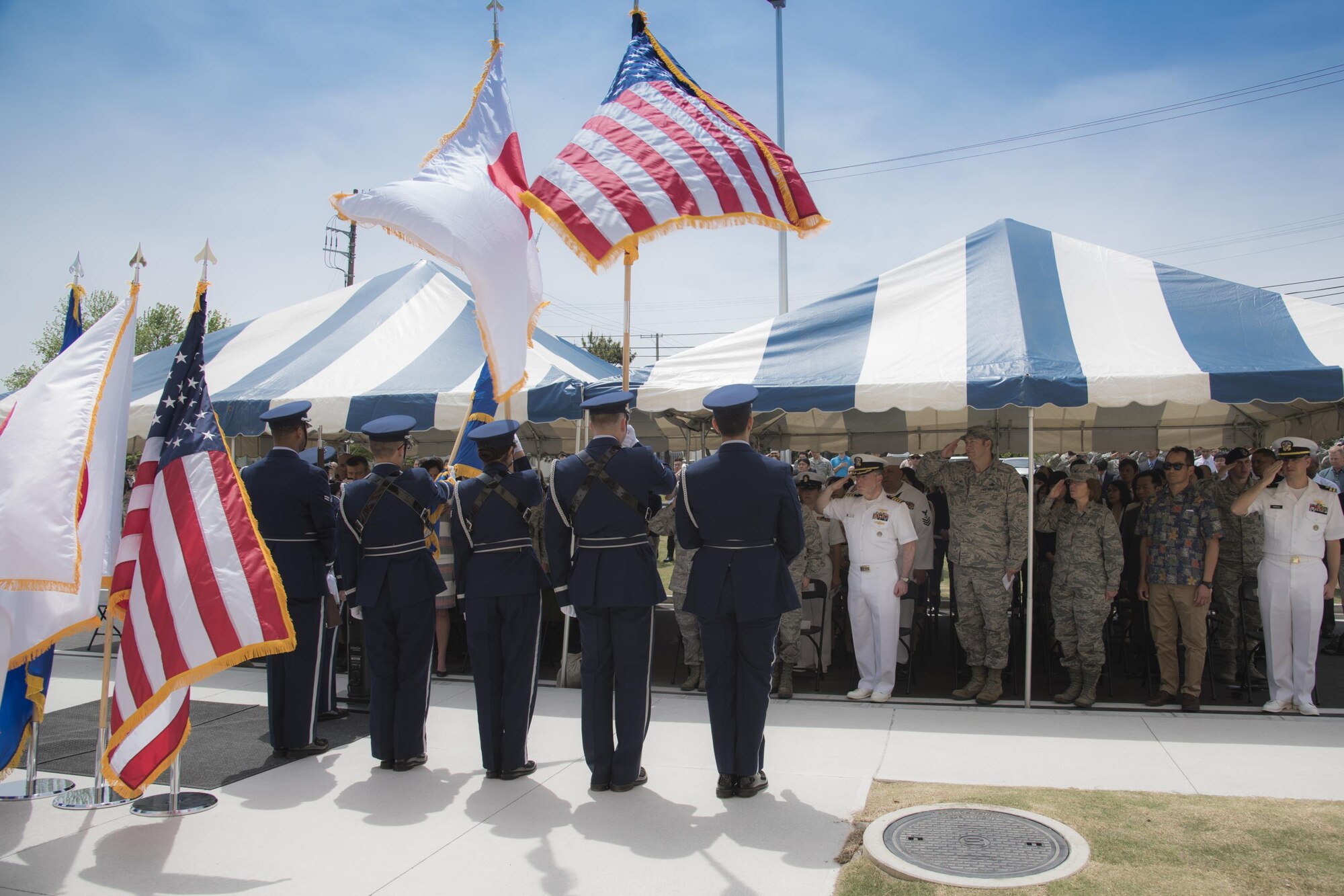 Base Honor Guard members hoist the colors for the singing of the National Anthem during the ribbon cutting ceremony of the new facility for the 374th Security Forces Squadron and Defense Finance and Accounting Service Japan at Yokota Air Base, Japan, May 3, 2017. The 374 SFS combined twelve functional areas from four separate facilities into one.  (U.S. Air Force photo by Machiko Arita)