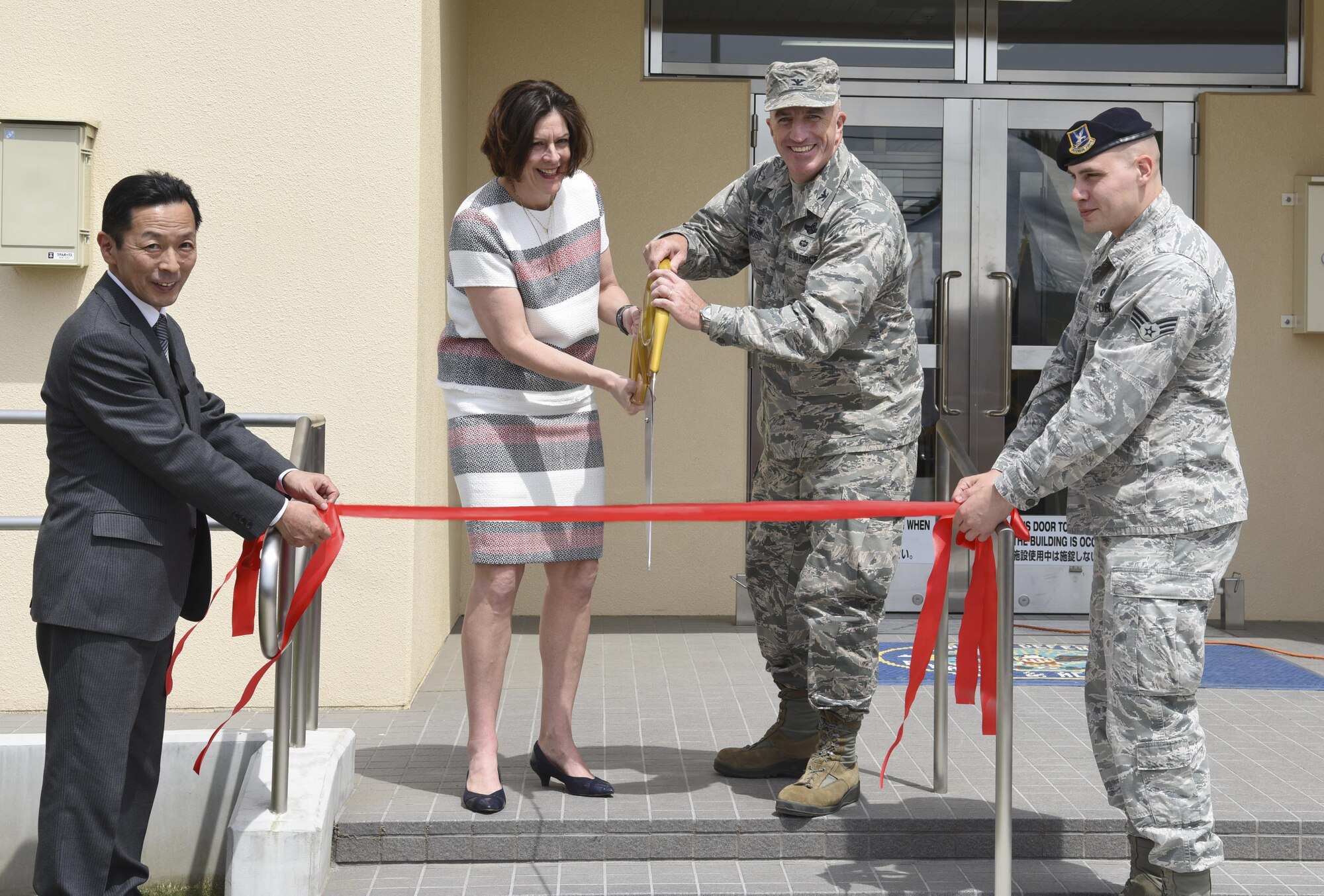 Col. Kenneth Moss, 374th Airlift Wing commander, and Teresa McKay, Defense Finance and Accounting Service director, cut the ribbon for the official opening ceremony for the 374th Security Forces Squadron and DFAS Japan’s new facility at Yokota Air Base, Japan, May 3, 2017. The new building is shared with the 374 SFS and DFAS Japan. Approximately 270 personnel will be working at the new building. (U.S. Air Force photo by Machiko Arita)