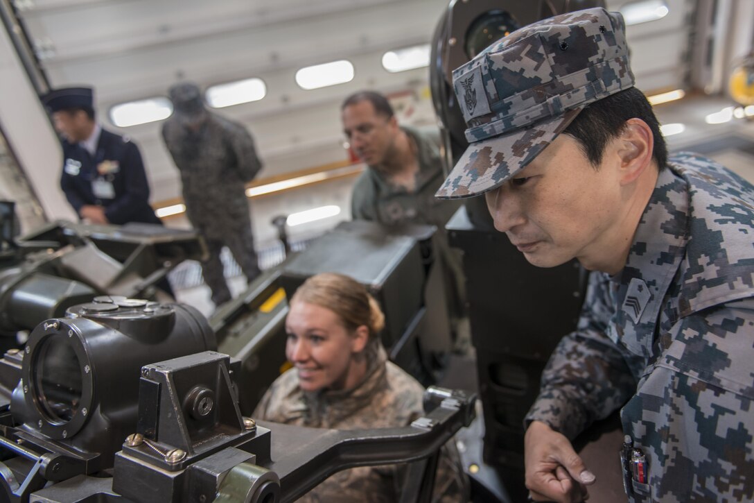 Koku-Jieitai Master Sgt. Hiroshi Osawa, right, a 2nd Air Wing Base Air Defense M-61 20 mm Vulcan cannon operator, explains the weapon’s capabilities to U.S. Air Force Tech. Sgt. Jessica Nienheuser, left, the 35th Medical Support Squadron patient administration section chief, during a 10-day U.S.-Japan Bilateral Career Training, at Chitose Air Base, Japan, April 12, 2017. Nienheuser got to sit in the operator’s seat while the weapon system was operational, not armed, and move the turret around while Osawa explained its operation. Koku-Jieitai is the traditional term for Japan Air Self Defense Force used by the Japanese. (U.S. Air Force photo by Tech. Sgt. Benjamin W. Stratton)