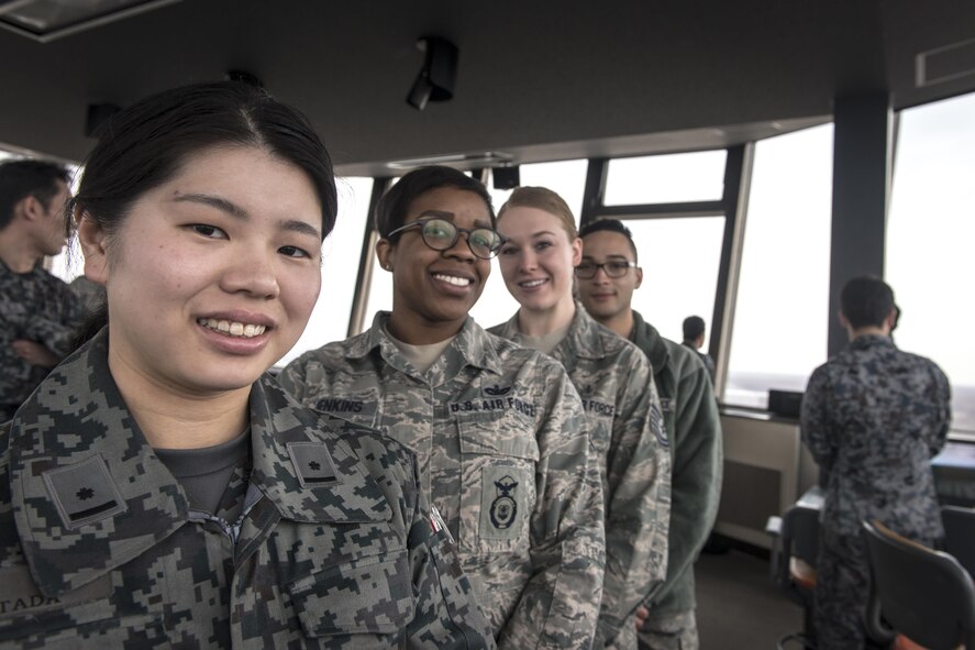 Koku-Jieitai 2nd Lt. Kanako Kitada, left, a 2nd Air Wing Air Traffic Control (ATC) Squadron air traffic controller, poses with three U.S. Airmen in the Chitose Air Base air traffic control tower during a tour and mission briefing as part of a 10-day U.S.-Japan Bilateral Career Training at Chitose Air Base, Japan, April 15, 2017. The ATC controls aircraft for both the Kokujieitai and commercial airport with runways on both sides of the tower. Koku-Jieitai is the traditional term for Japan Air Self Defense Force used by the Japanese. (U.S. Air Force photo by Tech. Sgt. Benjamin W. Stratton)