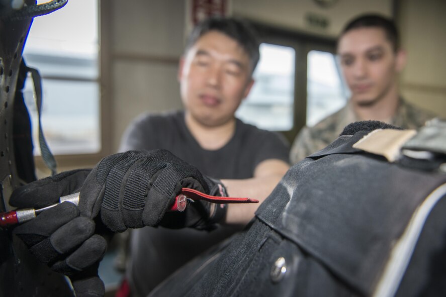 Koku-Jieitai Master Sgt. Shinichi Kishimoto, left, a 2nd Air Wing Aircrew Flight Equipment member, installs a parachute into an F-15J Eagle seat as U.S. Air Force Staff Sgt. James Berg, right, a 35th Operations Support Squadron aircrew flight equipment craftsman, observes during a 10-day U.S.-Japan Bilateral Career Training at Chitose Air Base, Japan, April 18, 2017. Working side-by-side with their Japanese counterparts, U.S. Airmen learned how the Koku-Jieitai executes their mission. Berg traveled from Misawa Air Base, Japan, with nine other U.S. Airmen for the bilateral exchange event. Koku-Jieitai is the traditional term for Japan Air Self Defense Force used by the Japanese. (U.S. Air Force photo by Tech. Sgt. Benjamin W. Stratton)