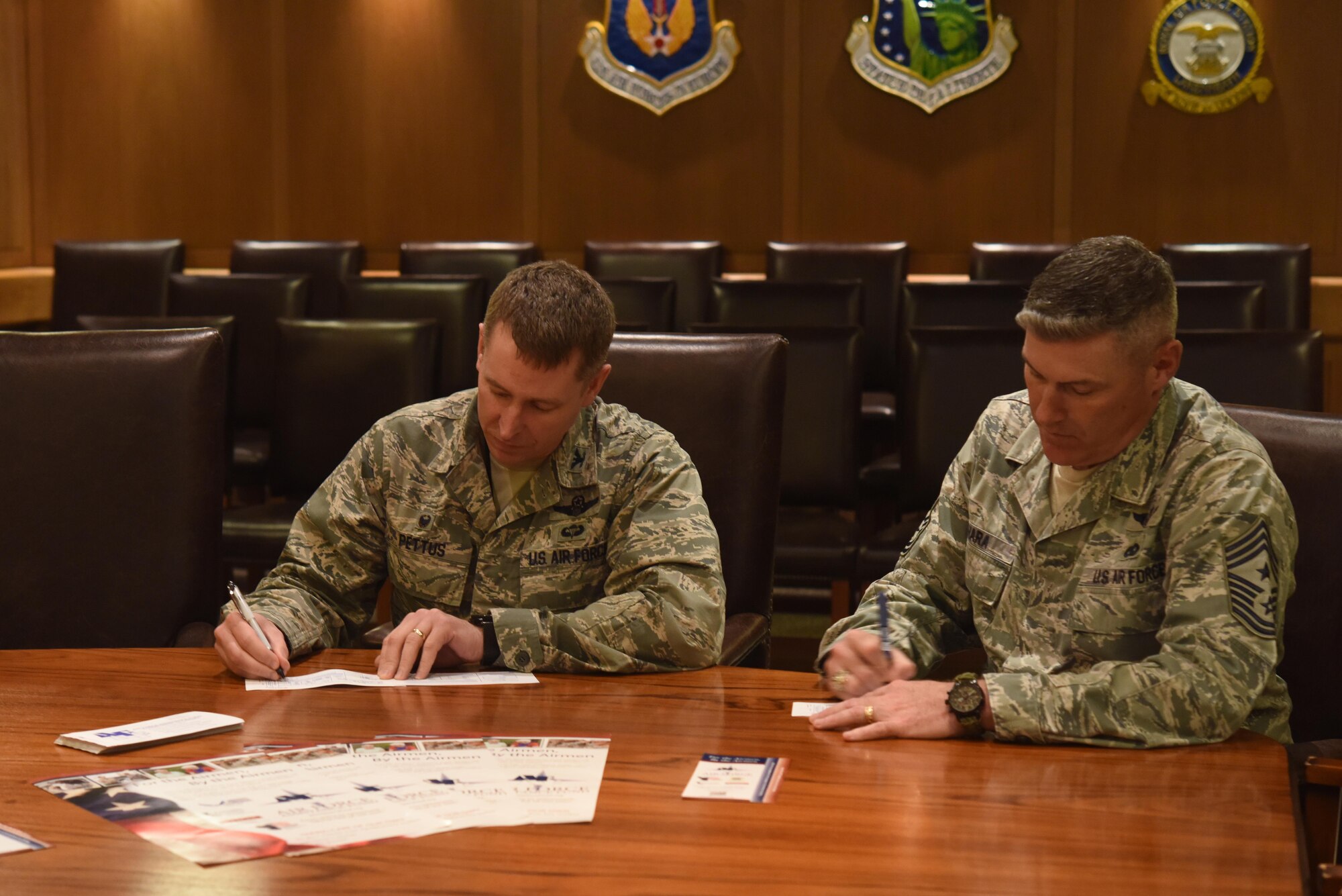 Col. Evan Pettus, 48th Fighter Wing commander, and Chief Master Sgt. David O'Hara, 48th FW command chief, sign contributions to the 2017 Air Force Assistance Fund campaign at Royal Air Force Lakenheath, England, May 4, 2017. Contributions support the Air Force Aid Society, Air Force Enlisted Village, Air Force Village, and the Gen. and Mrs. Curtis E. LeMay Foundation. (U.S. Air Force photo by Airman 1st Class Eli Chevalier)