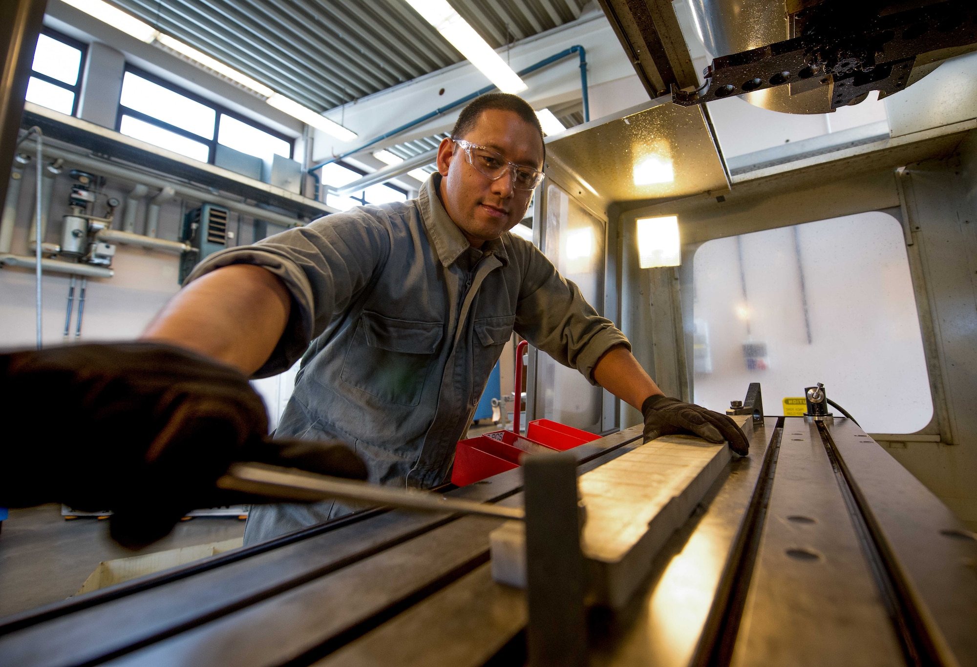 Staff Sgt. Mark Leyva, 86th Maintenance Squadron aircraft metals technology floor supervisor, secures an aluminum deck panel door support inside a computer numerical control milling machine on Ramstein Air Base, Germany, May 3, 2017.   Leyva is skilled in welding and machining parts and tools which other maintenance Airmen use to repair aircraft, enabling Ramstein to continue delivering airlift around the world in a timely manner. (U.S. Air Force photo by Senior Airman Elizabeth Baker/Released)