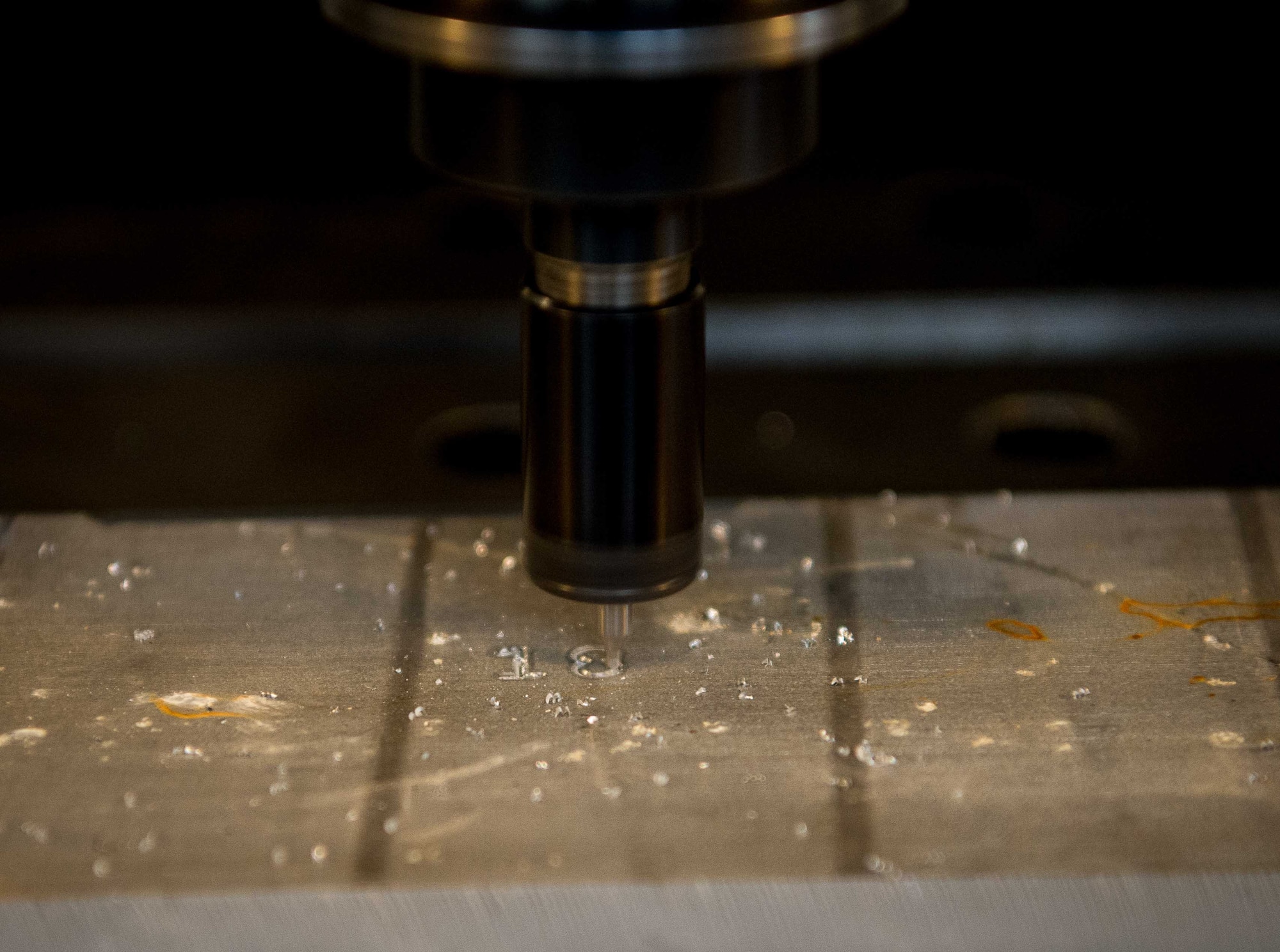 A computer numerical control milling machine grinds part numbers onto an aluminum deck panel door support on Ramstein Air Base, Germany, May 2, 2017. The 86th MXS Aircraft Metals Technology shop programs and uses the CNC machine to design and create 3-D shapes for use in aircraft and machinery repair. (U.S. Air Force photo by Senior Airman Elizabeth Baker/Released)