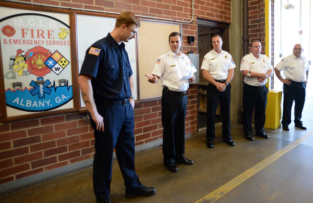 Philip Partin (second from left), fire chief, Marine Corps Logistics Base Albany, welcomes the installation’s newest firefighter to the team in a ceremony, here, May 3. Jonathan Kirkman (left), firefighter, MCLB Albany, is the first entry-level trainee to graduate from the Department of Defense Fire Academy at Goodfellow Air Force Base, San Angelo, Texas, in the history of the base.