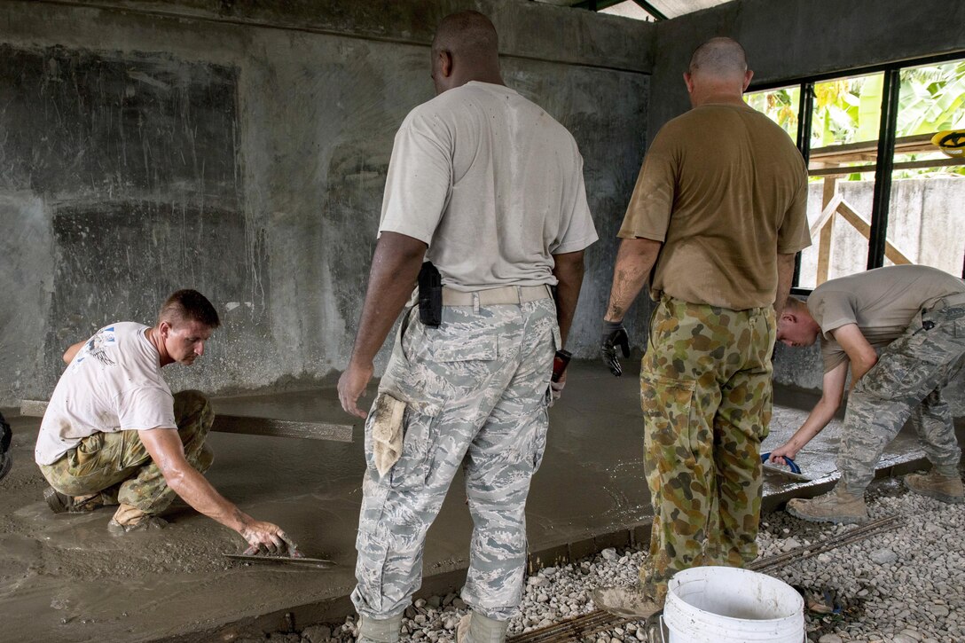 U.S. airmen and Australian soldiers smooth concrete for a classroom floor at Margen Elementary School in Ormoc City, Philippines, April 29, 2017, as part of exercise Balikatan 2017. Air Force photo by Staff Sgt. Peter Reft