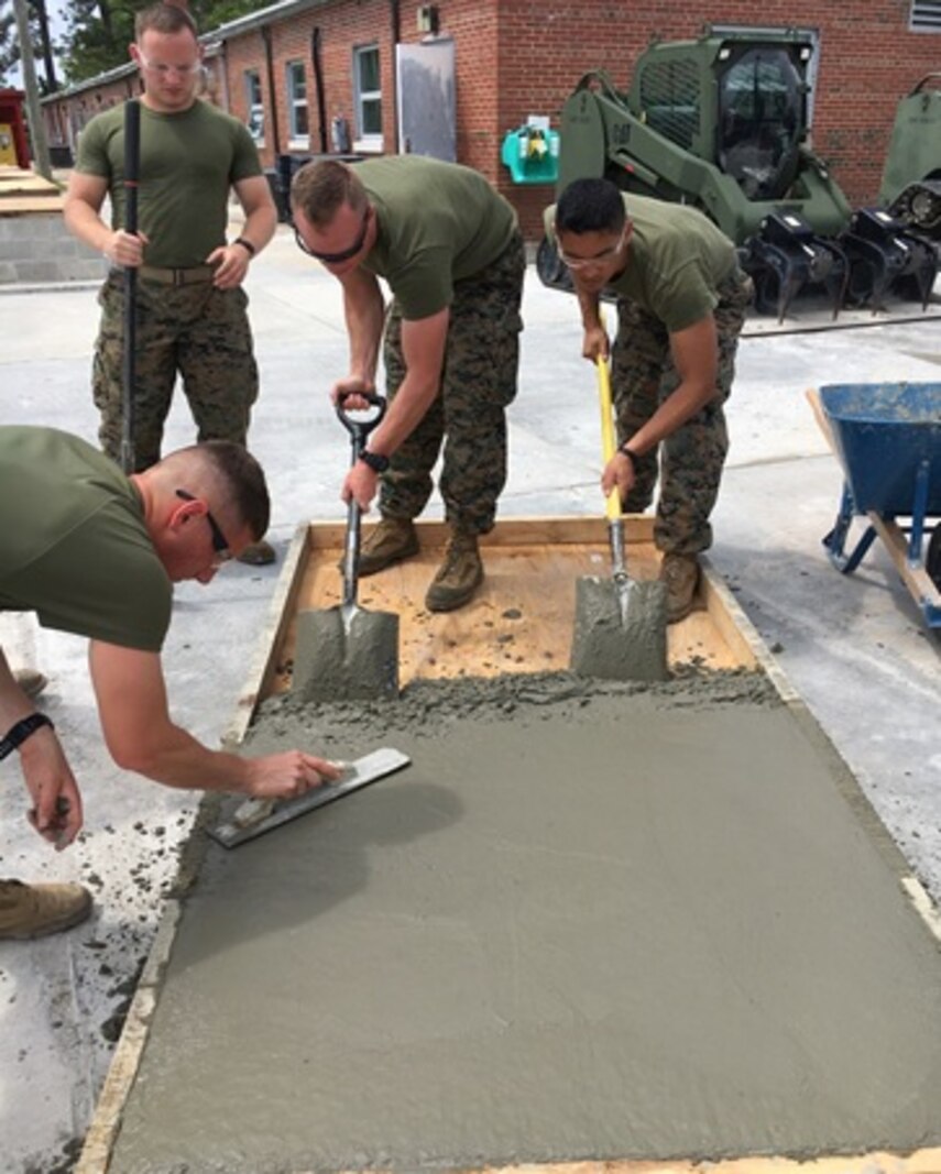 On May 1, 2017 students attached to Combat Engineer Officer course 4-17 (CEO 4-17) use a concrete float and shovels to smooth the concrete added to a form. CEO students learn how to calculate concrete production during this course at Marine Corps Engineer School in Camp Lejeune, N.C. Pictured from left to right: Second Lieutenants Camden Smith, Daniel Asheim, Andrew Shrader, and Jonathan Lapadula. 
