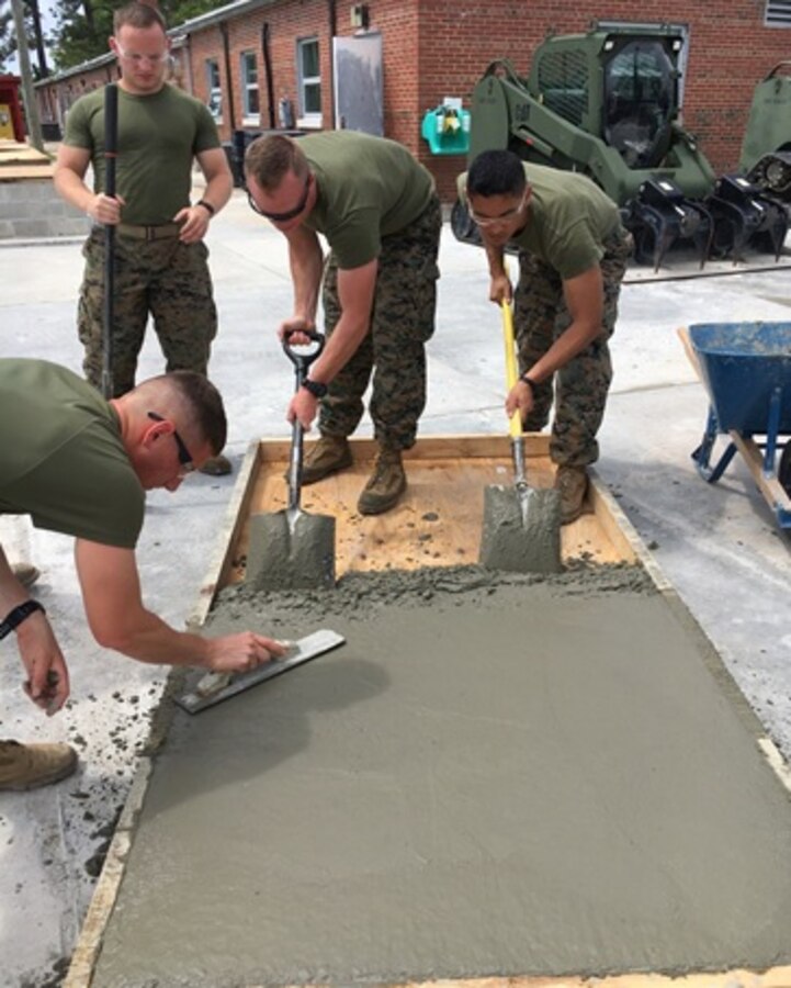 On May 1, 2017 students attached to Combat Engineer Officer course 4-17 (CEO 4-17) use a concrete float and shovels to smooth the concrete added to a form. CEO students learn how to calculate concrete production during this course at Marine Corps Engineer School in Camp Lejeune, N.C. Pictured from left to right: Second Lieutenants Camden Smith, Daniel Asheim, Andrew Shrader, and Jonathan Lapadula. 
