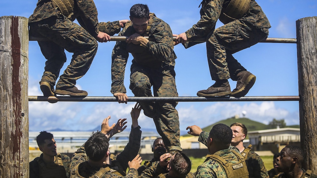 Marines Corps Cpl. Omar Perez receives help from fellow Marines over a double bar during the obstacle course portion of the Martial Arts Instructor Course at Marine Corps Base Hawaii, May 1, 2017. The Marines are assigned to the 11th Marine Expeditionary Unit. Marine Corps photo by Cpl. Zachary Orr