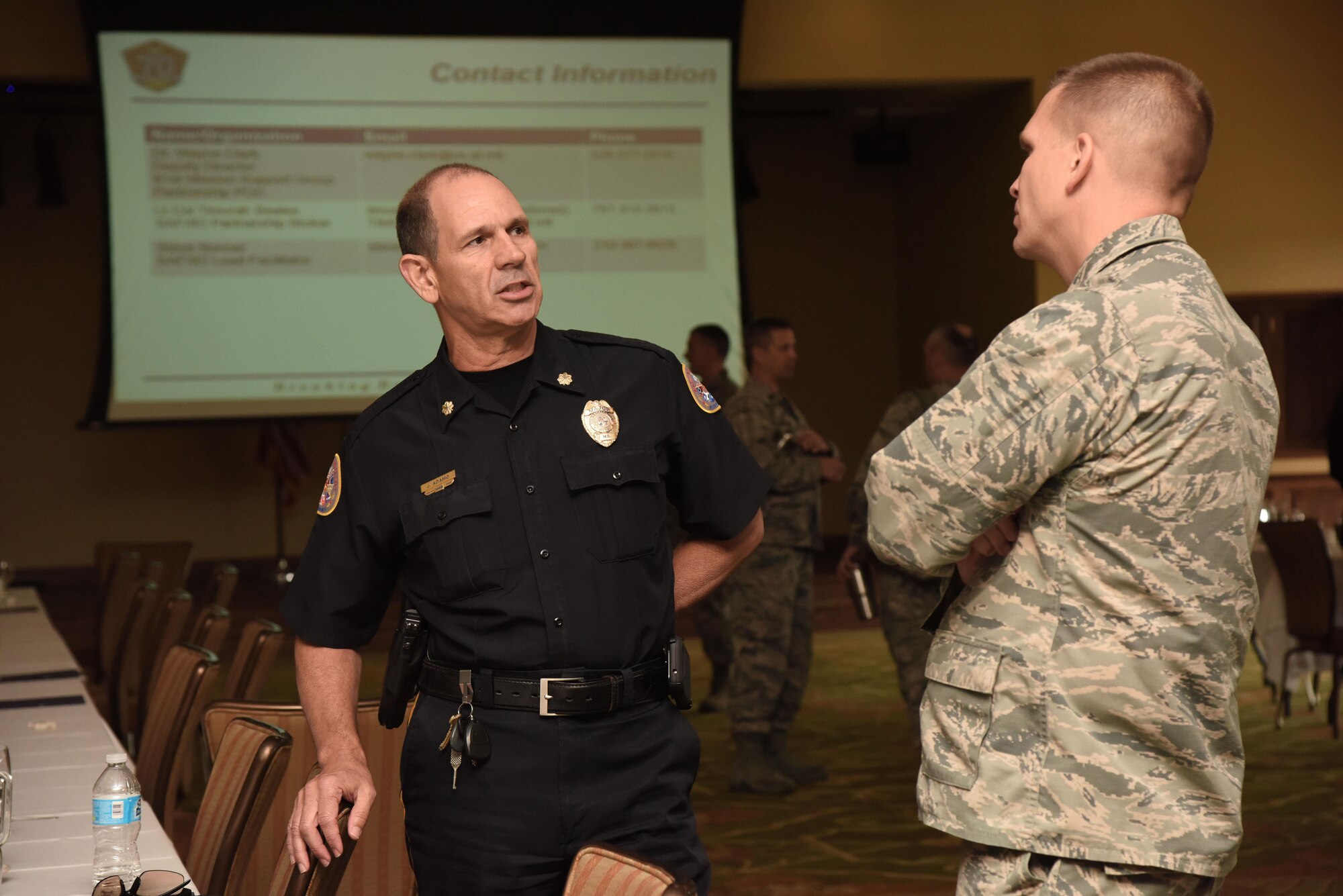 Maj. Jim Adamo, Biloxi Police Department patrol commander, speaks with Maj. Devin Sproston, 81st Security Forces Squadron commander, during the Air Force Community Partnership Program kick-off meeting at the Bay Breeze Event Center May 3, 2017, on Keesler Air Force Base, Miss. The program is designed to leverage military and local community capabilities and resources to achieve mutual value and benefit in support of the Air Force and its business partners. (U.S. Air Force photo by Kemberly Groue)