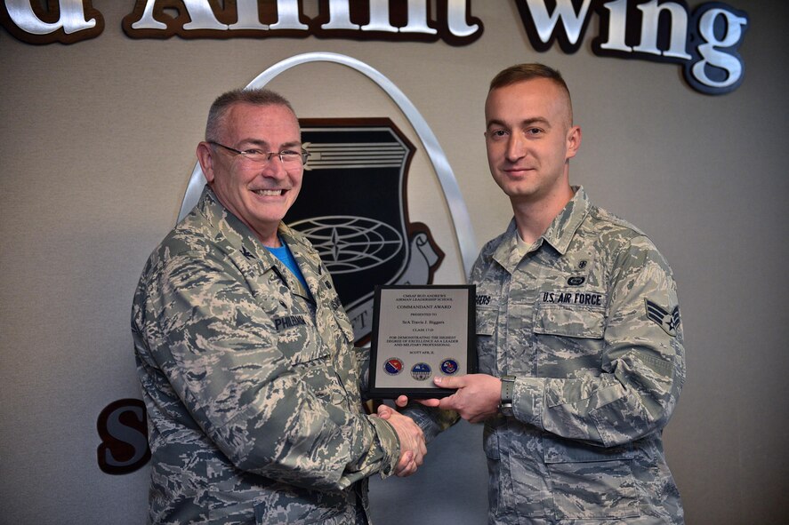 Col. Jonathan M. Philebaum, commander, 932nd Airlift Wing, takes time during the Wing Review meeting May 5, 2017 to honor and present Senior Airman Travis J. Biggers the Commandant Award plaque Biggers earned for demonstrating leadership and military professionalism  while attending the Chief Master Sergeant of the Air Force Bud Andrews Airman Leadership School Scott Air Force Base, Illinois. "This award means a lot as I was recognized as a leader in a leadership school," said Biggers about winning the Commandant Award.  He added that he felt the instructors saw him as a leader amongst his peers and awarded him for his contributions to his class.   (U.S. Air Force photo by Christopher Parr)