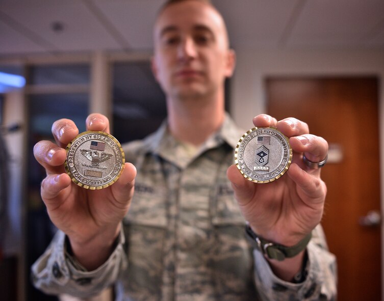 Senior Airman Travis J. Biggers displays the two challenge coins he received from 932nd Airlift Wing leadership May 5, 2017, Scott Air Force Base, Illinois, for his accomplishments while attending the Chief Master Sergeant of the Air Force Bud Andrews Airman Leadership School Scott Air Force Base.   (U.S. Air Force photo by Christopher Parr)