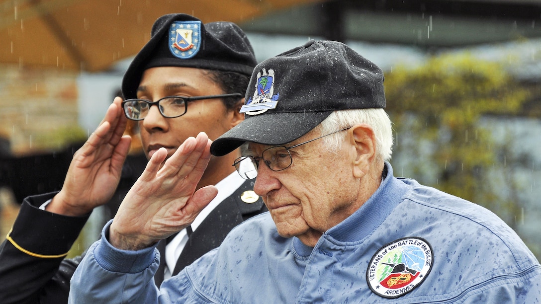 Retired Army Col. Douglas Dillard, right, and Army Staff Sgt. Natasha Love salute during a ceremony marking the 72nd anniversary of the capture of Obersalzberg, Germany, and the last major military operation of World War II in Garmisch, Germany, May 5, 2017. Dillard, a 91-year-old World War II veteran who fought in the Battle of the Bulge, spoke during the event. DoD photo by James E. Brooks