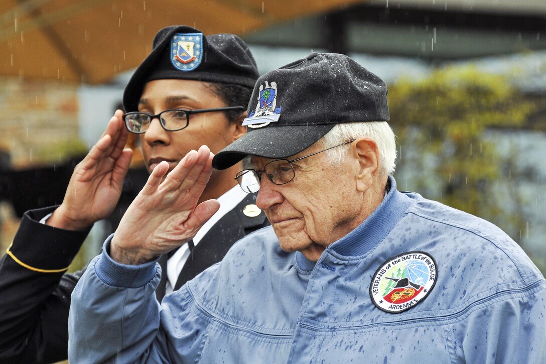 Retired Army Col. Douglas Dillard, right, and Army Staff Sgt. Natasha Love salute during a ceremony marking the 72nd anniversary of the capture of Obersalzberg, Germany, and the last major military operation of World War II in Garmisch, Germany, May 5, 2017. Dillard, a 91-year-old World War II veteran who fought in the Battle of the Bulge, spoke during the event. DoD photo by James E. Brooks