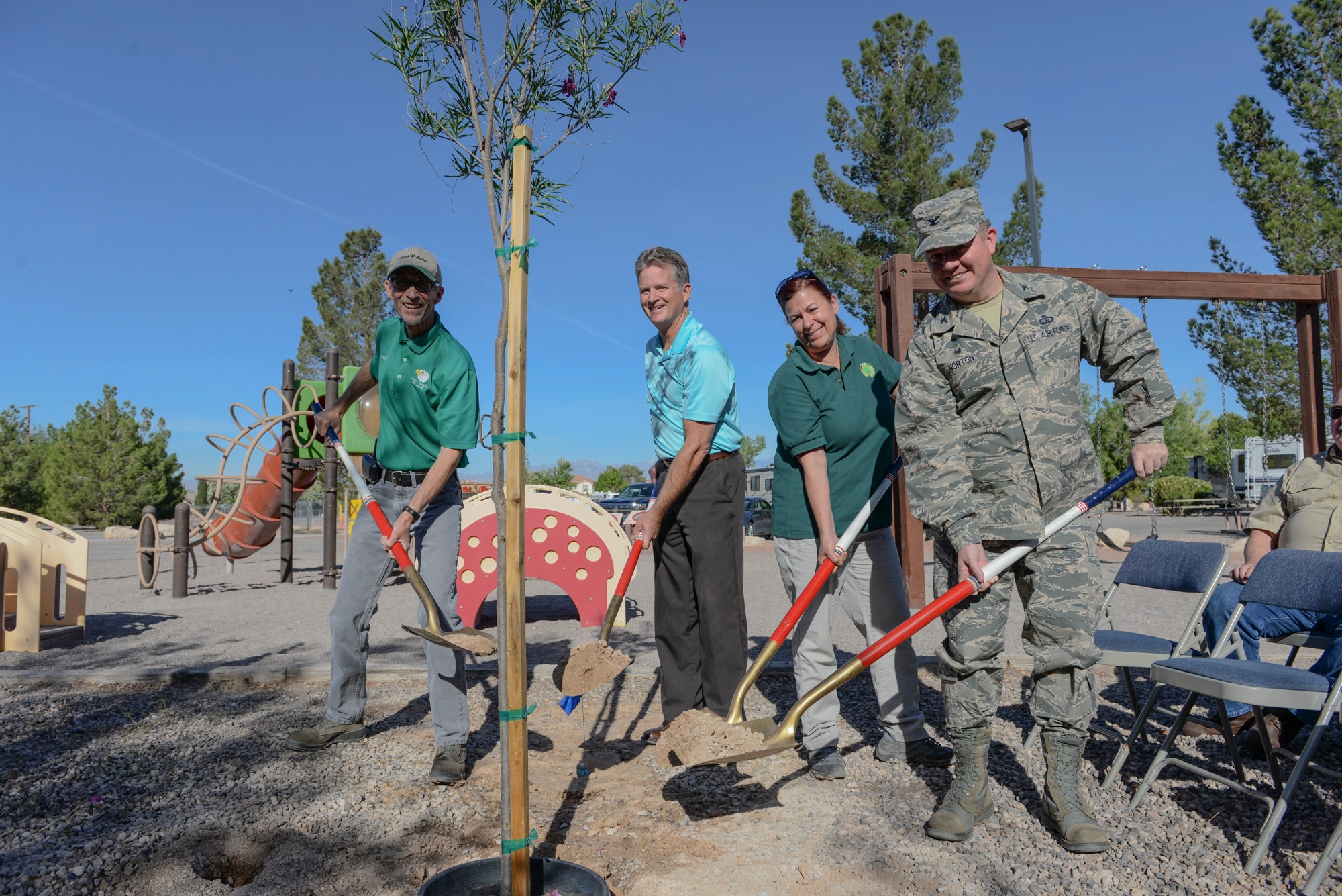 Base and community leadership prepare to plant a Desert Willow tree at the Desert Eagle RV Park playground on Nellis Air Force Base, May 3, 2017. Two Desert Willow trees and two Arizona Ash trees were planted here to celebrate Arbor Day. Both trees are native to the desert ecosystem for their ability to thrive in low water and high heat conditions. (U.S. Air Force photo by Airman 1st Class Andrew D. Sarver/Released)