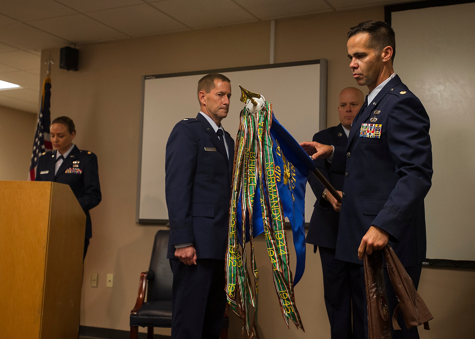 (from left) Lt. Col. John Robinson, 315th Operations Group commander, watches Maj. Hamilton Underwood, the units commander, unravel the 4th CCTS colors during a unit reactivation and assumption of command ceremony at Joint Base Charleston, S.C., May 5. The 4th CTCS, which was formally assigned to March Air Reserve Base in Riverside, Calif., deactivated in July 2015, but was reactivated and relocated to the 315 AW due to mission need. (U.S.Air Force Photo by Michael Dukes)