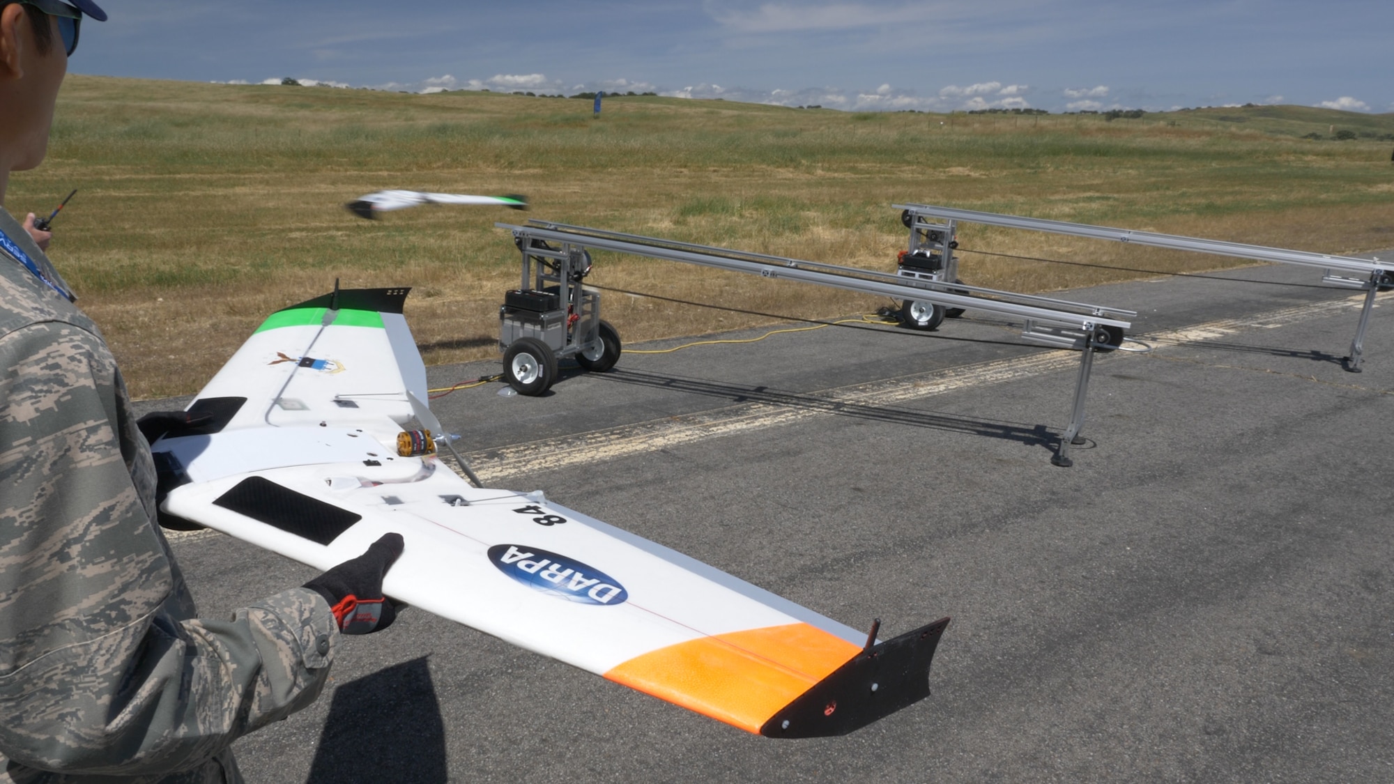 An Airman prepares to launch a small unmanned aerial vehicle in April at Camp Roberts, California. Cadets and midshipmen from the Air Force Academy, the U.S. Military Academy and the U.S. Naval Academy, competed in the Defense Advanced Research Projects Agency-sponsored Swarm Competition at the camp, April 23-25, 2017. During the competition, teams of cadets and midshipmen flew the small UAVs in swarm formation while protecting territory on the ground. (U.S. Air Force photo)