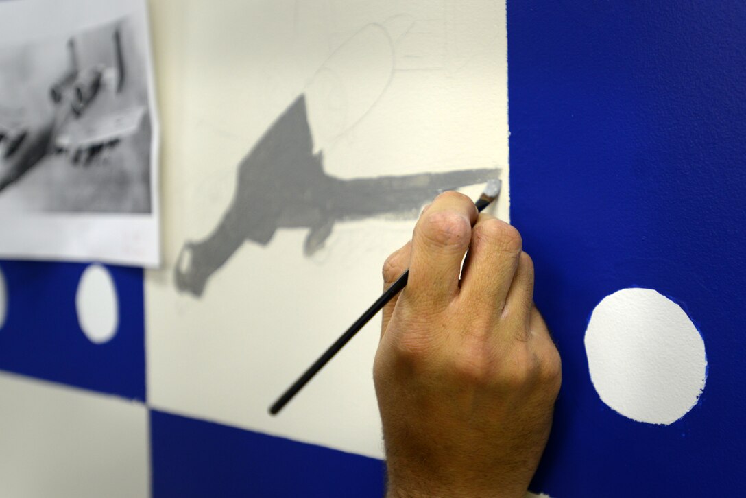 U.S. Air Force Tech. Sgt. Brian Barnes, 20th Aircraft Maintenance Squadron, 55th Aircraft Maintenance Unit (AMU) tactical aircraft maintainer, applies a base layer of paint to a mural in the 55th AMU at Shaw Air Force Base, S.C., Feb. 10, 2017. The mural, extending across an entire 12 x 5 1/2 foot wall, took Barnes a total of nearly 55 hours – stretched across four months – to complete. The mural is dedicated to the 55th Fighter Squadron’s 100th anniversary on Aug. 9. (U.S. Air Force photo by Airman 1st Class Kelsey Tucker)