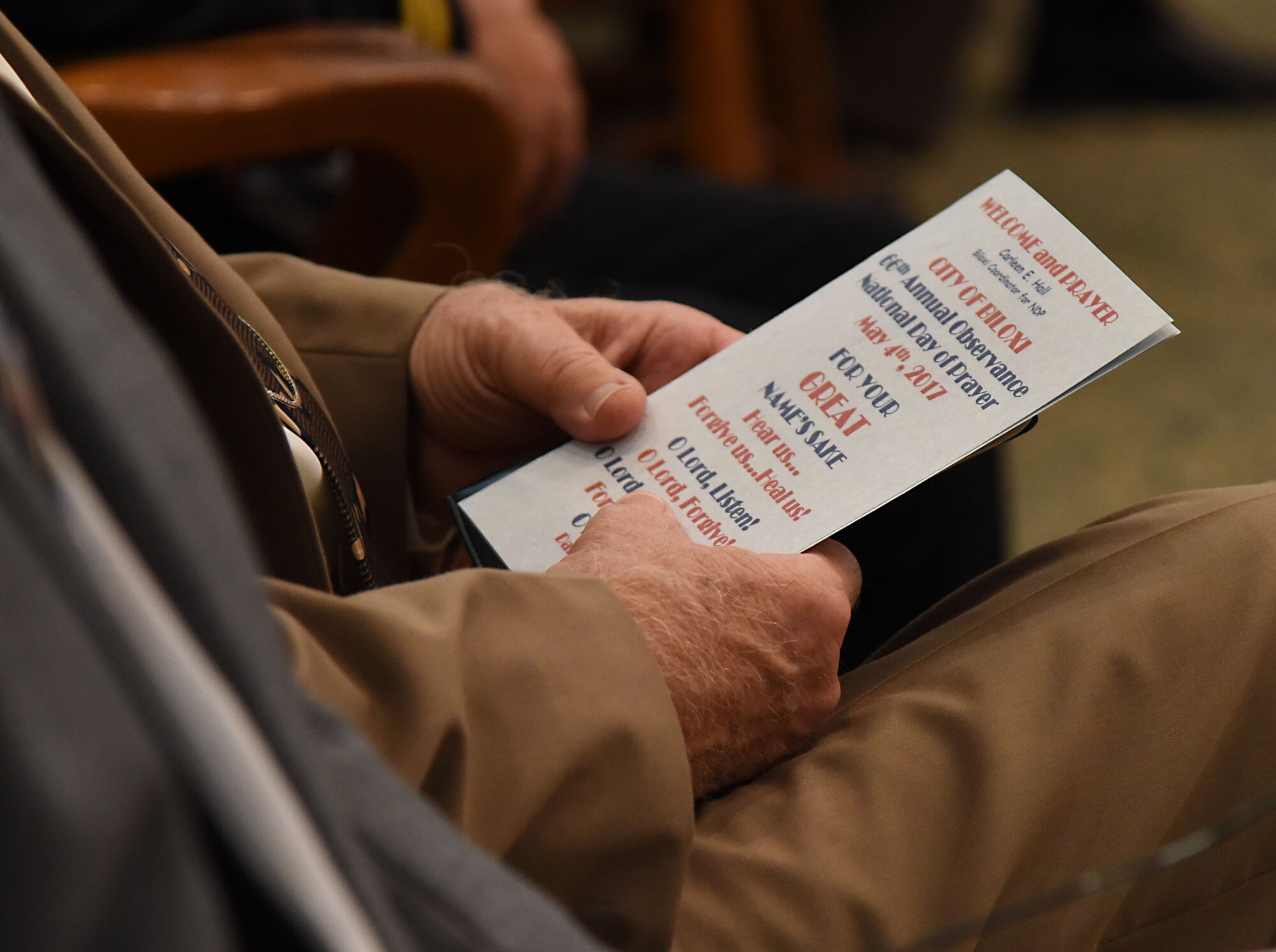 An attendee of the City of Biloxi’s 66th Annual Observance National Day of Prayer at Biloxi City Hall May 4, 2017, Biloxi, Miss., holds one of the programs associated with the event. The National Day of Prayer is an annual national observance dating back to a call in a joint resolution of Congress signed into law by President Harry S. Truman in 1952. (U.S. Air Force photo by Kemberly Groue)