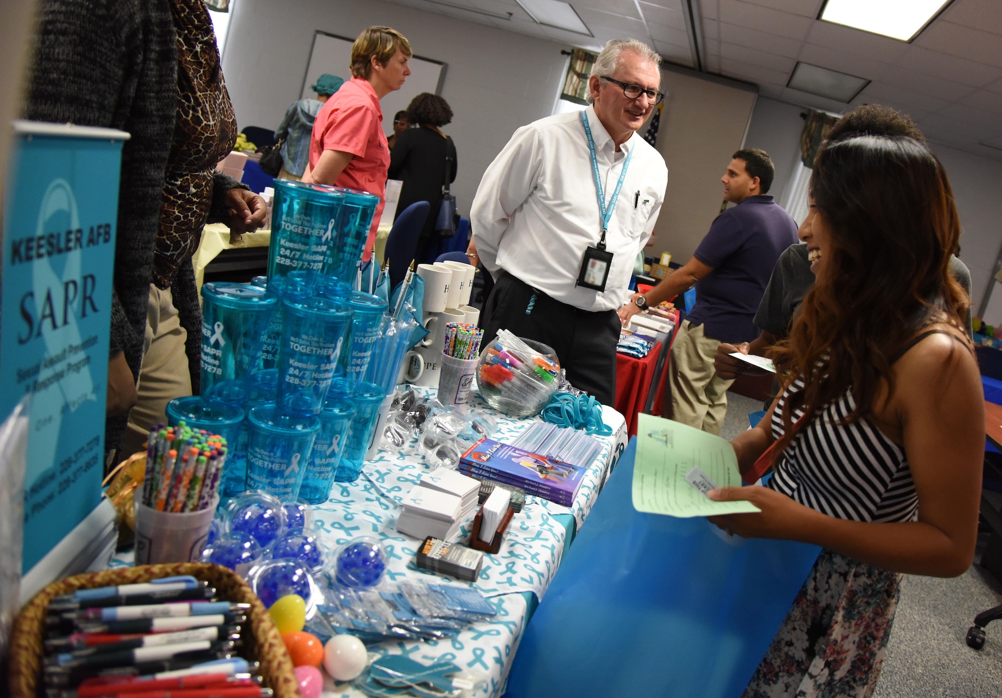 Barry Newman, sexual assault victim advocate, provides information about the sexual assault prevention and response program to Alana Trujillo, spouse of Staff Sgt. Javier Trujillo, 334th Training Squadron instructor, during Pamper Me Day at the Sablich Center May 4, 2017, on Keesler Air Force Base, Miss. Keesler’s Airman and Family Readiness Center has hosted the event for the past 13 years, offering spouses free manicures, make-up styling tips and information and business booths. (U.S. Air Force photo by Kemberly Groue)