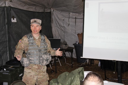 Capt. Robert Reynolds, an observer controller/trainer in 1st Brigade, Great Lakes Training Division, 75th Training Brigade, explains the course of action development step of the Military Decision Making Process to members of the 419th Combat Service Support Battalion, headquartered in Tustin, California.