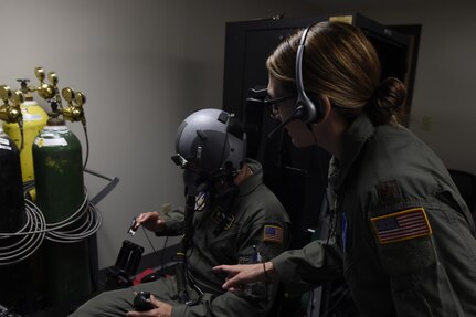 Maj. Kasie Gaona, Air Force Reservist, prepares a student for Aerospace Physiology refresher training using the Reduced Oxygen Breathing Device and Hypoxia Familiarization Trainer May 3. By using the device, Airmen receive their five-year required physiology training in a realistic simulation, locally and without the risks associated with the hypobaric chamber. 
