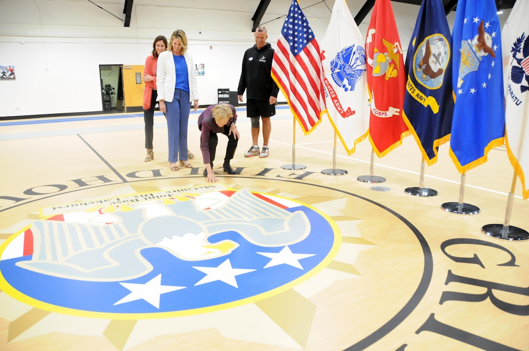During the re-opening ceremony for the Col. Jack H. Griffith Jr. Memorial Field House on Joint Base McGuire-Dix-Lakehurst, New Jersey, Griffith’s widow Bonnie admires the newly painted center court as daughters Barb and Megan look on along with Mark Smith, Griffith Field House fitness director. The field house re-opened May 5 following a 5-month, $750,000 transformation. In addition to receiving a new gym floor and running track, the field house now features energy-efficient lighting and is compliant with the Americans with Disabilities Act. Col. Griffith served as Fort Dix chief of staff from March 1984 until his death from cancer in December 1986. He was commissioned as an Infantry officer through the Reserve Officers’ Training Corps at the University of Virginia, and was a graduate of the Army War College. He served two tours of duty in Vietnam where he was wounded in combat, and served in many other assignments around the world during his 26-year career.