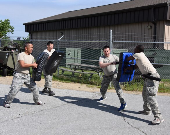 NEW CASTLE AIR NATIONAL GUARD BASE, Del. - Airman First Class Chris Davidson, defender, 166th Security Forces Squadron, utilizes a baton to hold off three fellow defenders including Master Sgt. Bonifacio Tee, far left, Staff Sgt. William Mason III, second from left, and Staff Sgt. Yusef Abrams, far right during an asp baton training session held on May 4, 2017. (U.S. Air National Guard photo by Tech. Sgt. Gwendolyn Blakley/Released).