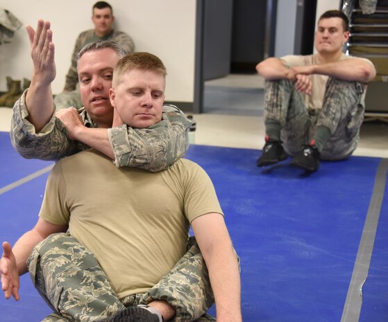 NEW CASTLE AIR NATIONAL GUARD BASE, Del. - Master Sergeant Timothy Luko, chief of information protection, 166th Security Forces Squadron, demonstrates a “rear- naked chock hold maneuver” with Staff Sgt. Jason Duricek, defender, 166th Security Forces Squadron, during a training session demonstrating combative techniques on May 4, 2017. (U.S. Air National Guard photo by Tech. Sgt. Gwendolyn Blakley/Released).
